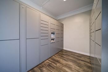a walk in closet with gray cabinets and white walls